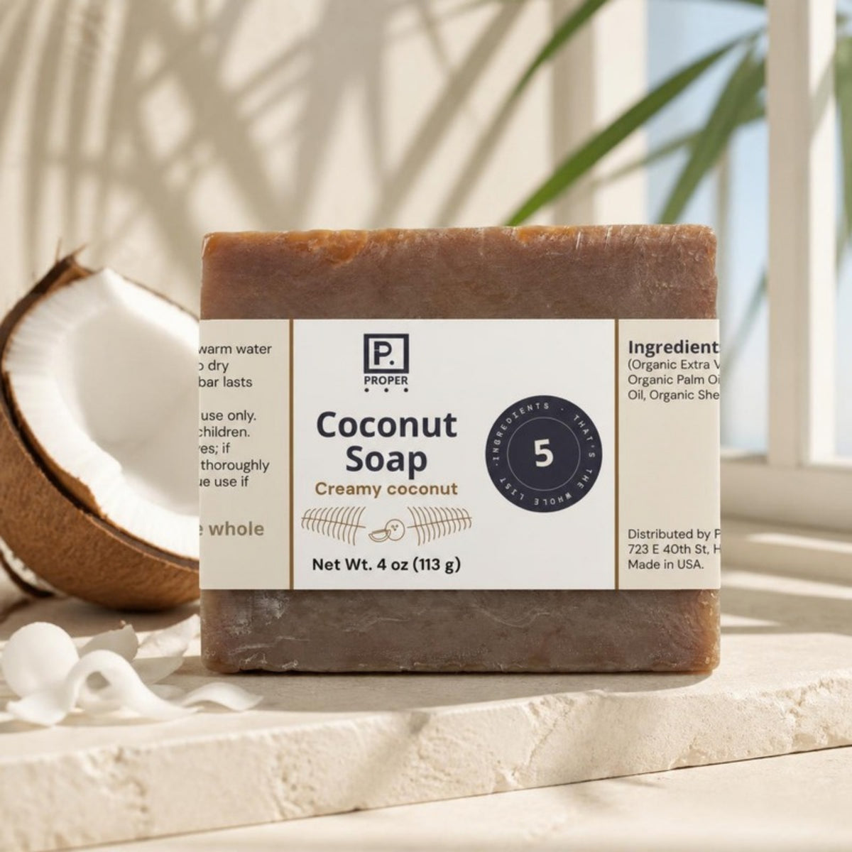Proper Coconut Soap on a sunny stone ledge with fresh coconut